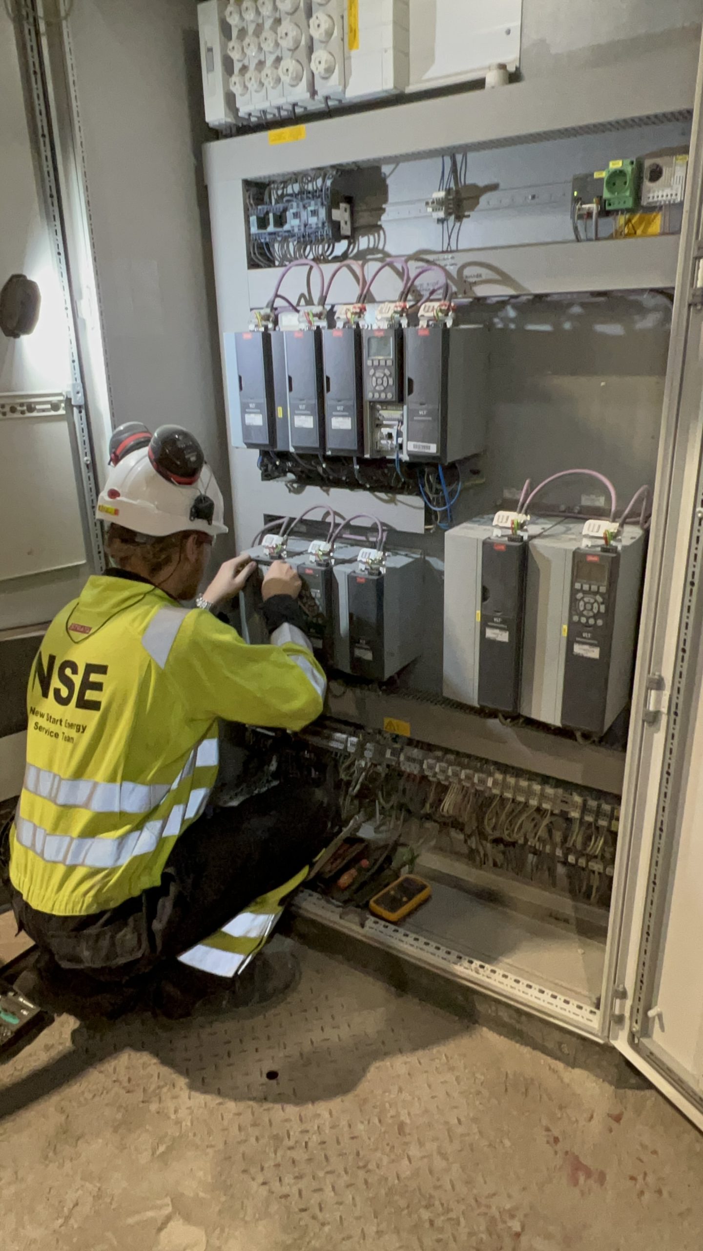 VSD repair engineer diagnosing an ABB drive control cabinet on site
